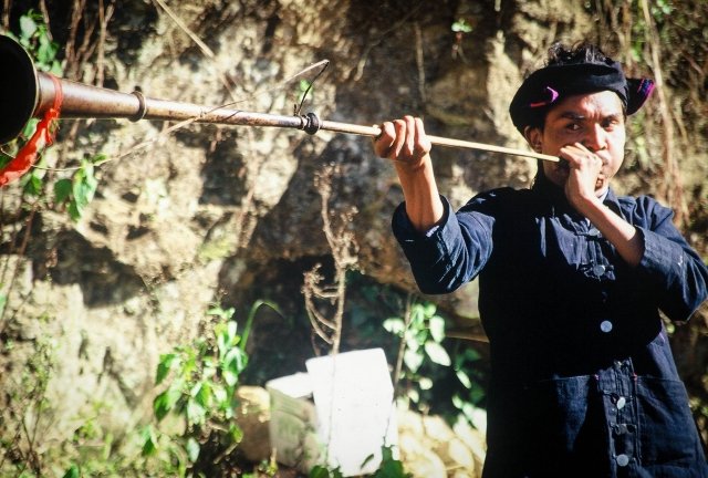 akha man making trumpet call